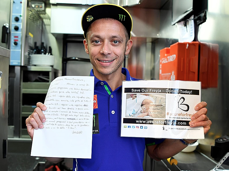 Valentino Rossi holding the love letter to his Yamaha M1