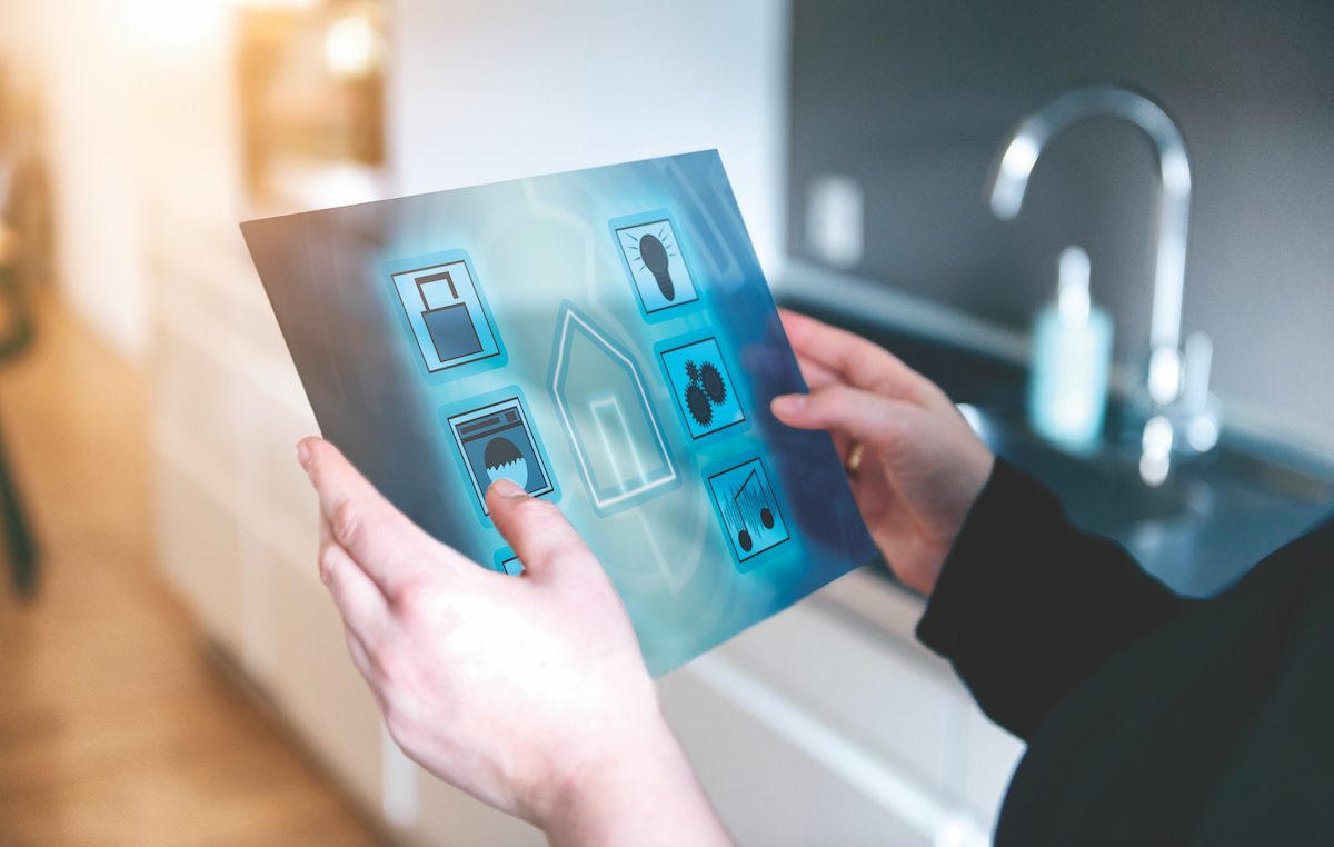 Woman uses digital tablet to control items in smart home