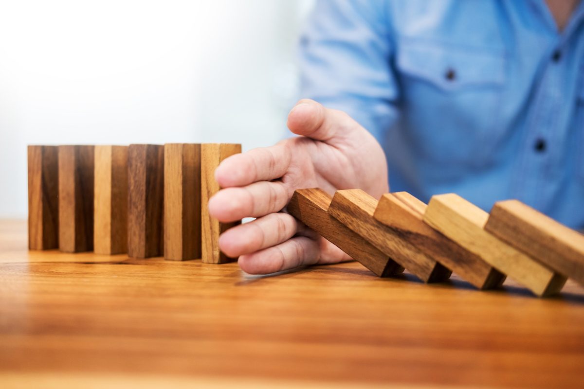Close-Up Of Man With Wooden Dominos On Table Disruption