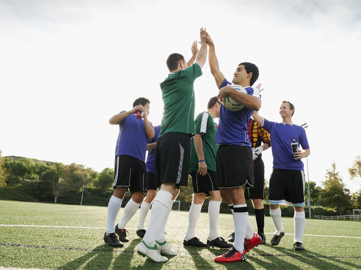 Soccer players cheering on soccer field soccer team playing soccer