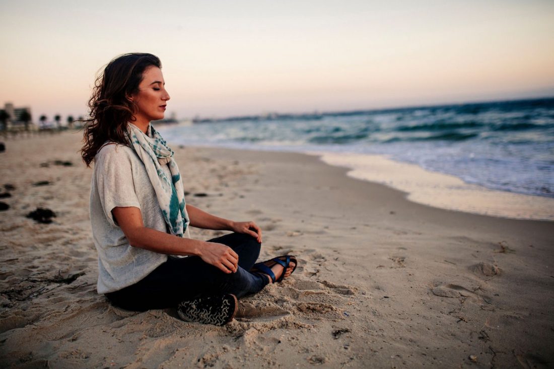 person-meditating Person meditating on the beach