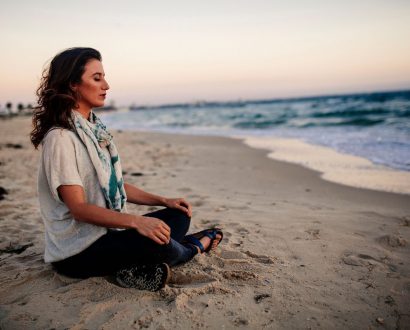 Person meditating on the beach