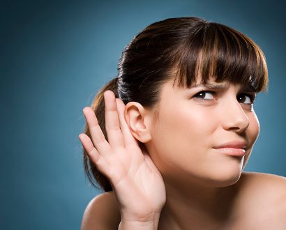 Woman with hand behind hear so she can listen better