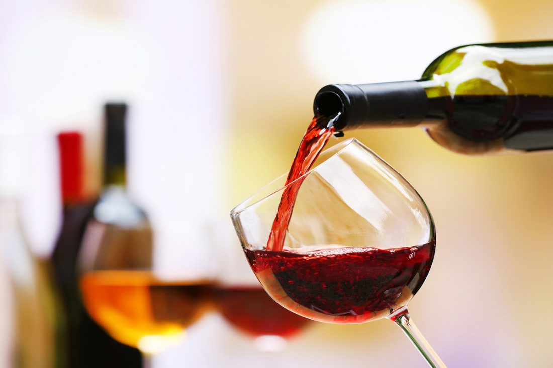 Red wine pouring into wine glass, close-up vegan pouring red wine into a wine glass